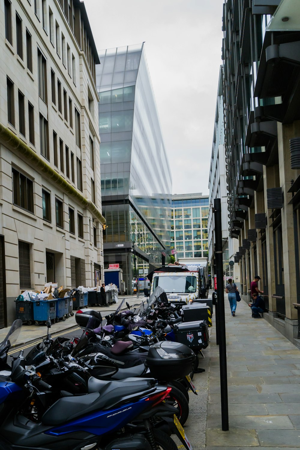 a row of motorcycles parked on the side of a street