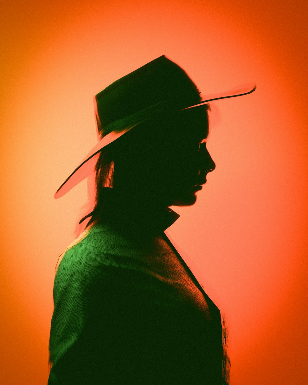 a silhouette of a man wearing a hat