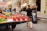 Families enjoying the lively outdoor market with children tasting fresh fruit samples.