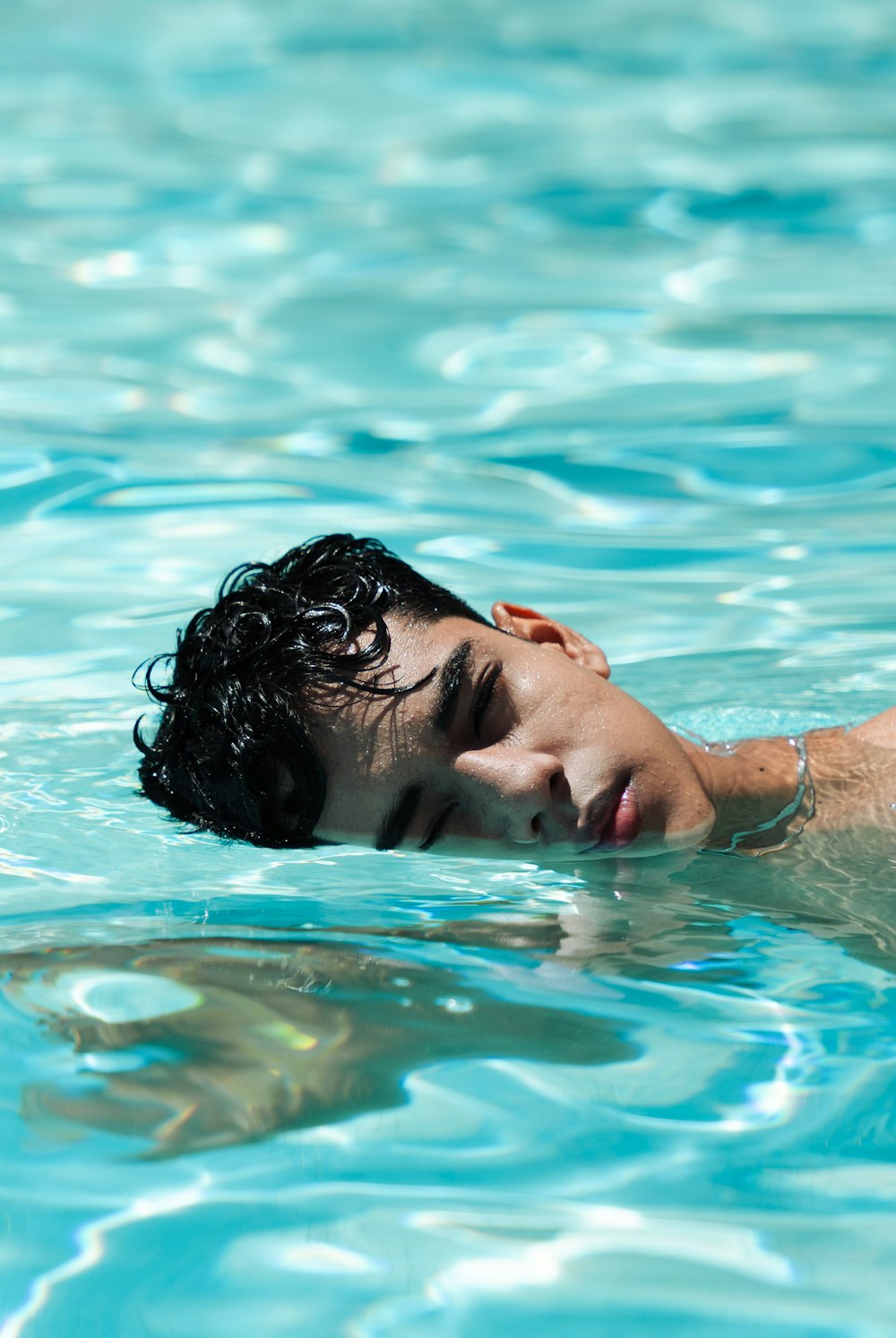 a young man swimming in a pool of water