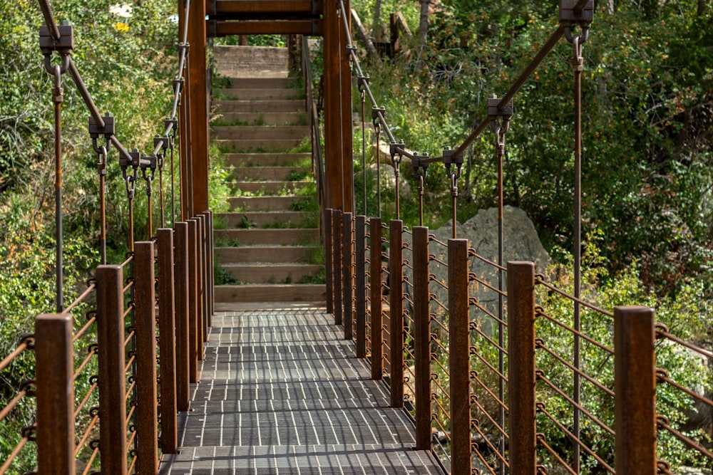 a wooden bridge with metal railings over a river