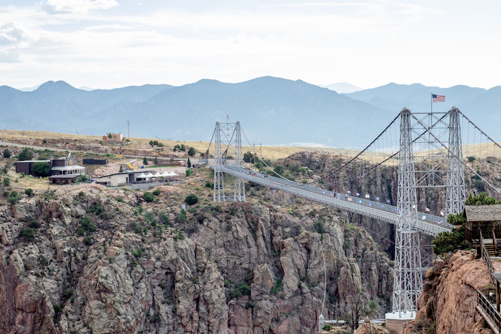 a bridge over a canyon with a mountain in the background