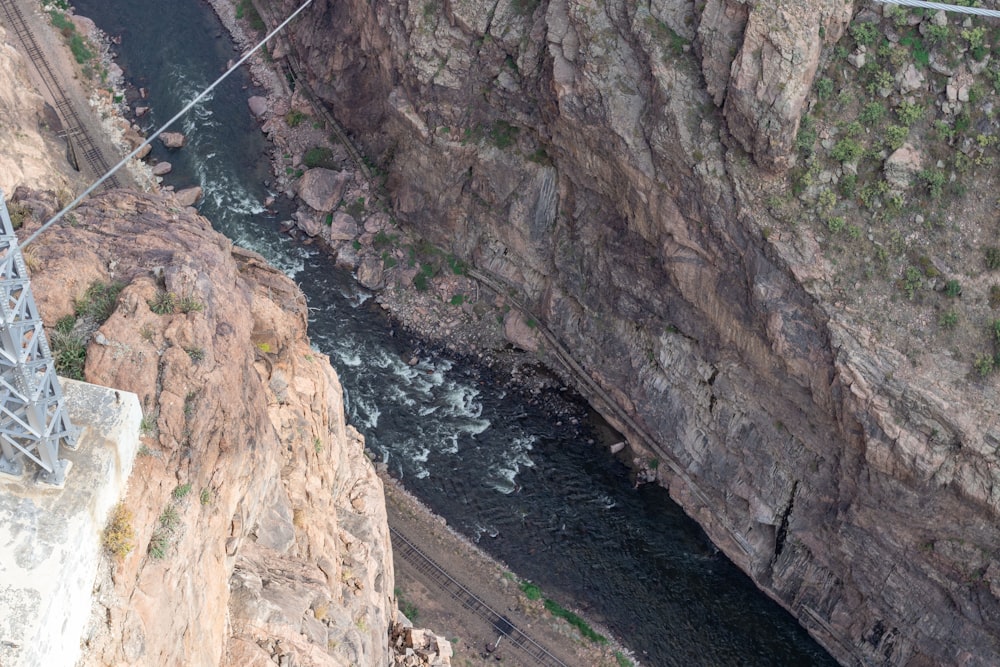 Ein Mann, der über eine Hängebrücke über einen Fluss geht