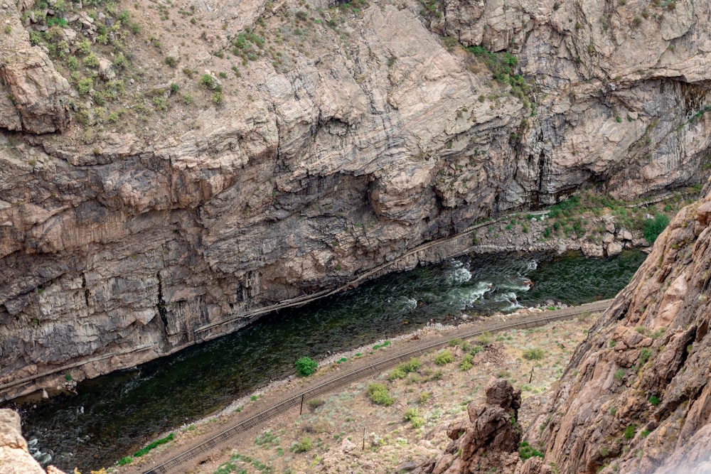une rivière qui traverse un canyon à côté d’une falaise