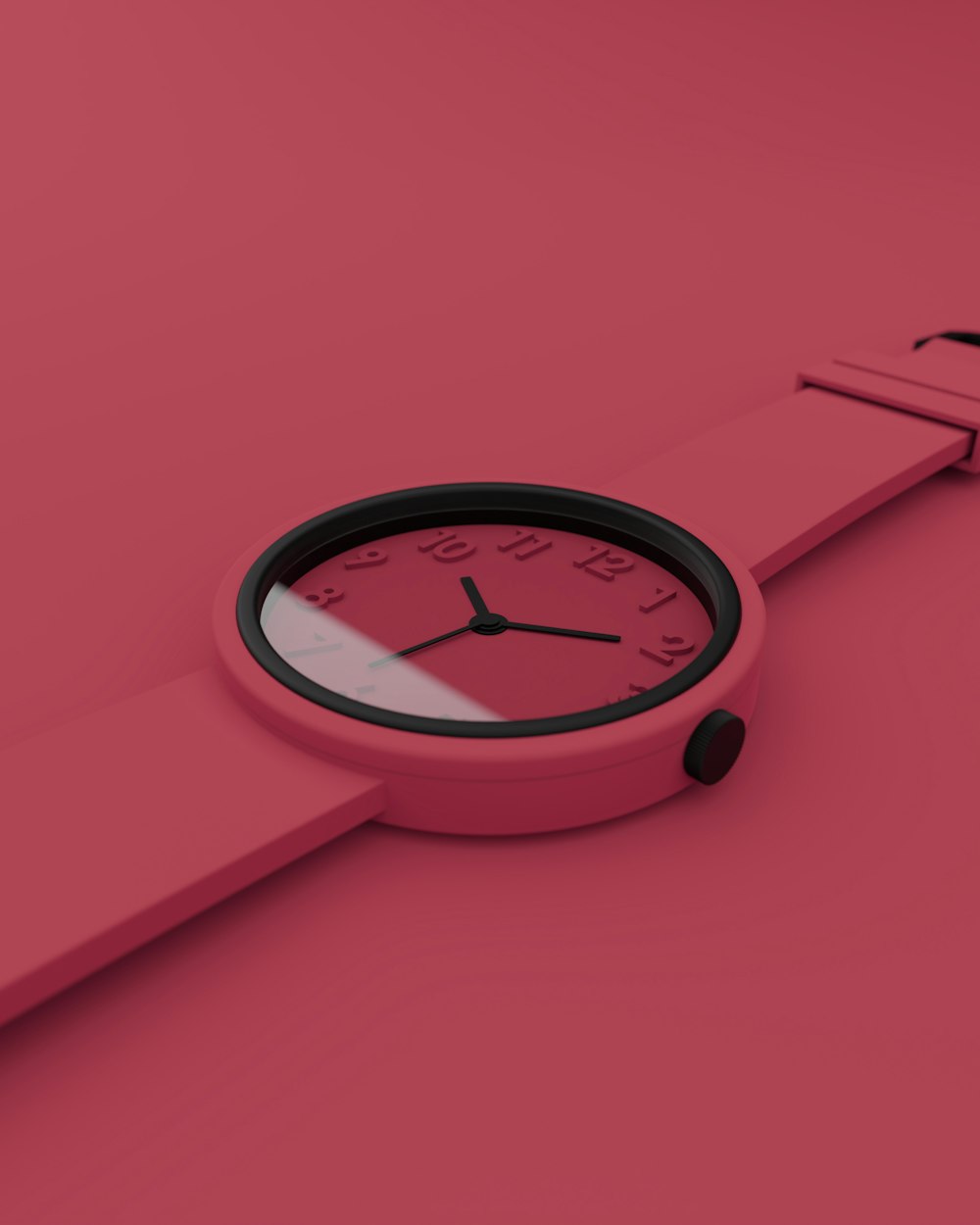 a pink watch with a black face on a pink surface