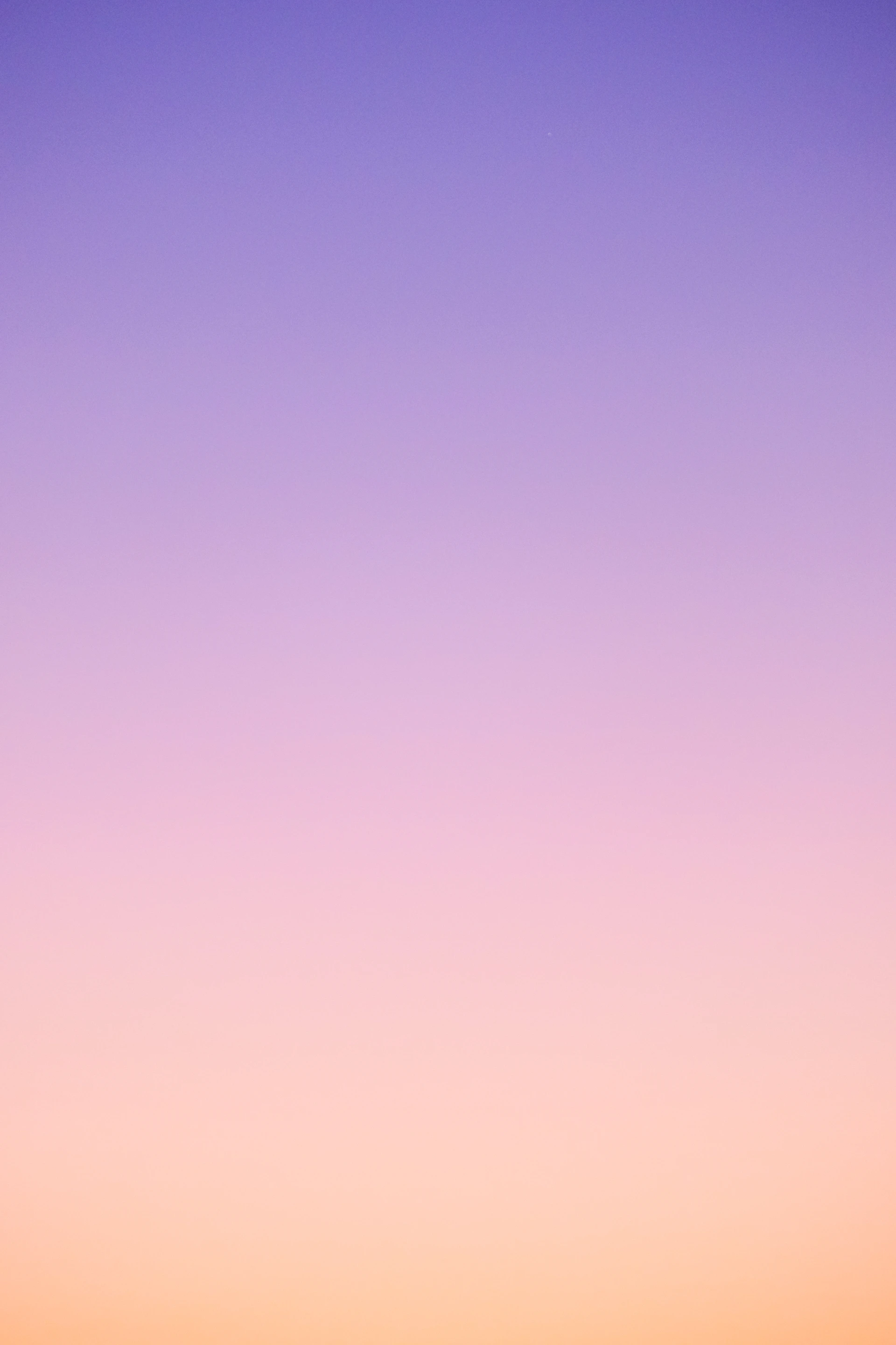 a plane flying in the sky at sunset