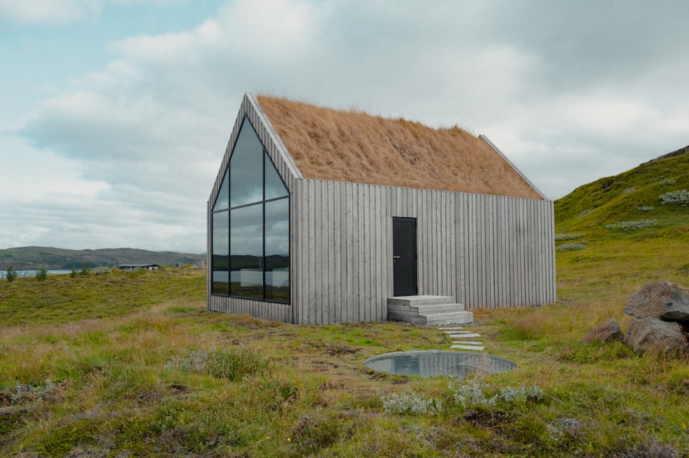 une petite maison avec un toit en herbe et des escaliers