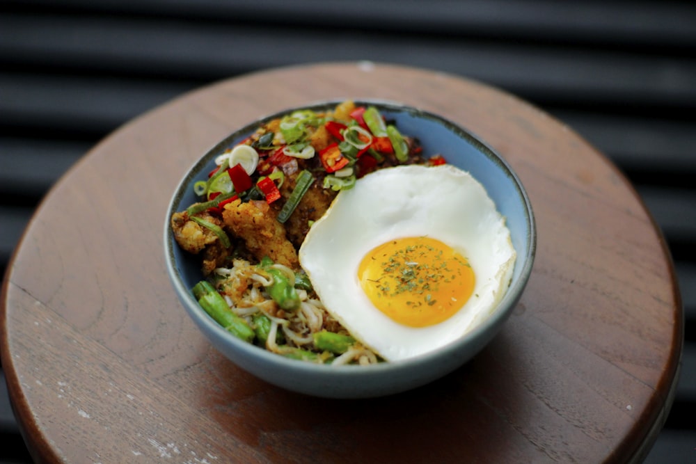 a bowl of food with an egg on top of it