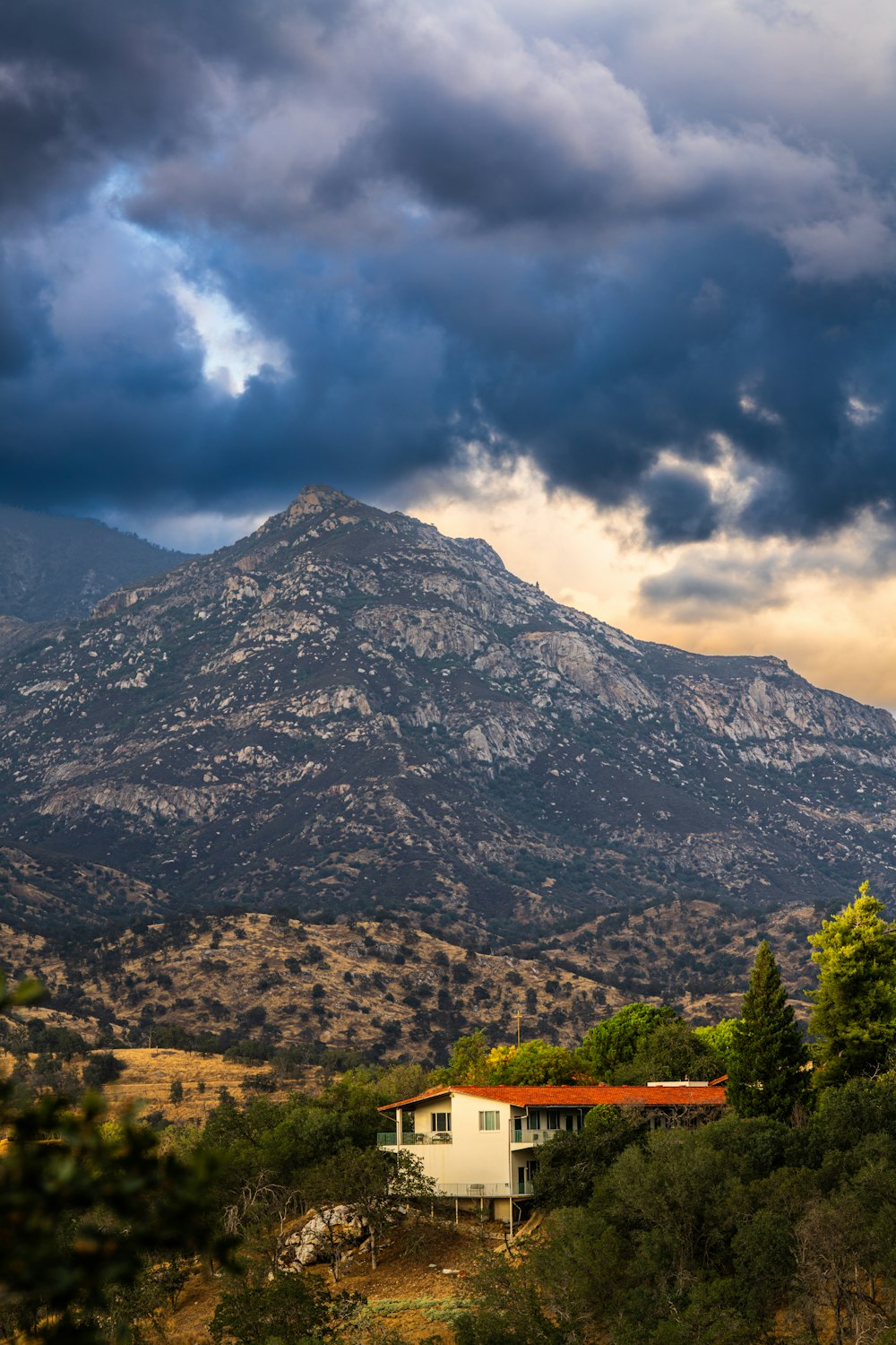 a house in the foreground with a mountain in the background