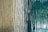 A close-up of a textured surface with flowing vertical lines resembling wood grain patterns, featuring a blend of earthy beige and deep teal colors.