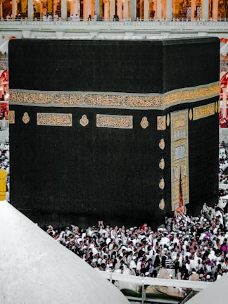 The Kaaba surrounded by worshippers in a vibrant atmosphere.