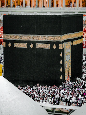 A serene view of the Kaaba inside Masjid al-Haram with pilgrims gathered around in prayer.
