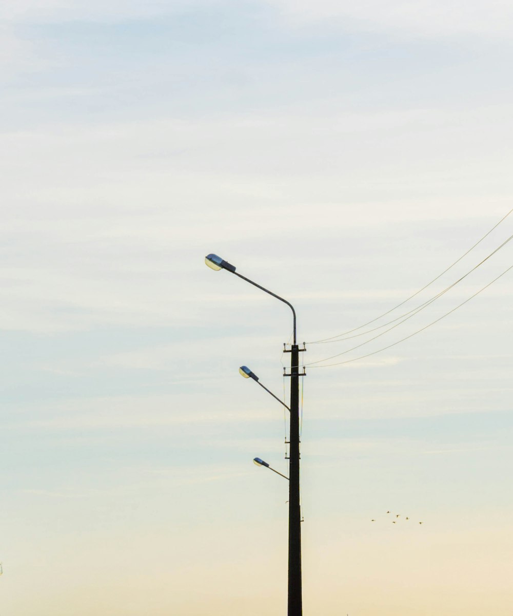 uma luz de rua em um poste com um fundo do céu