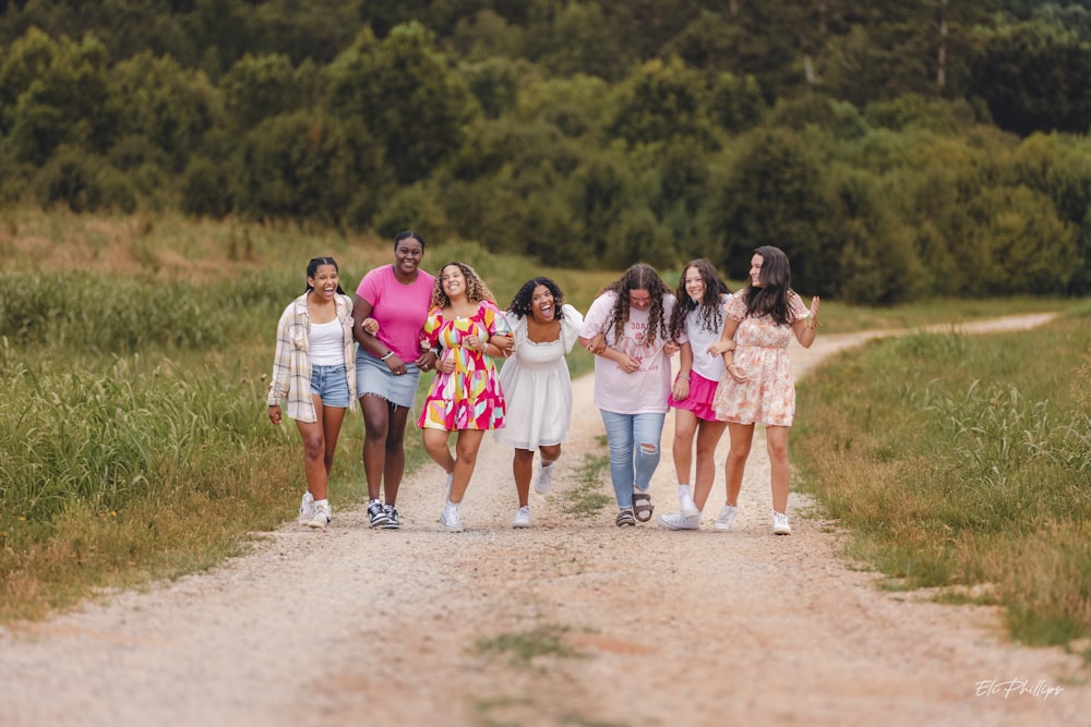 a group of people walking down a dirt road