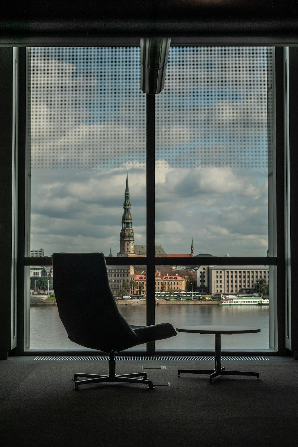 a chair sitting in front of a window overlooking a city