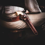 Cinematic close-up of a gunslinger’s hand gripping a revolver in a dusty desert town