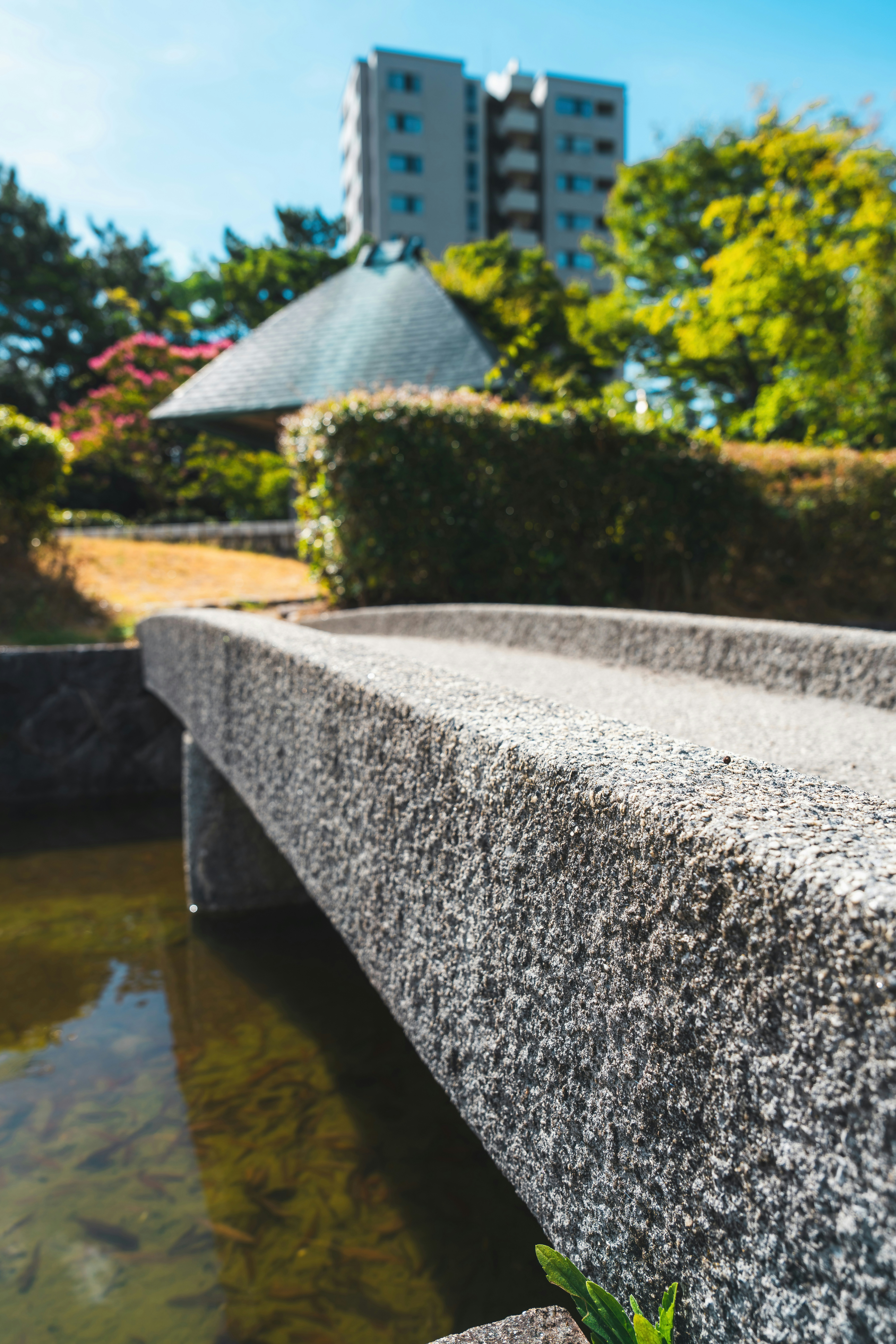 a stone bench sitting next to a body of water