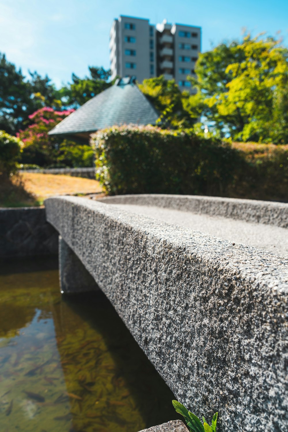 a stone bench sitting next to a body of water