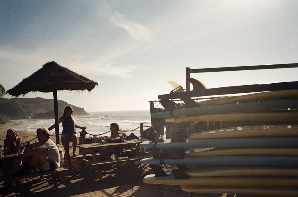 a group of people sitting on a beach next to the ocean