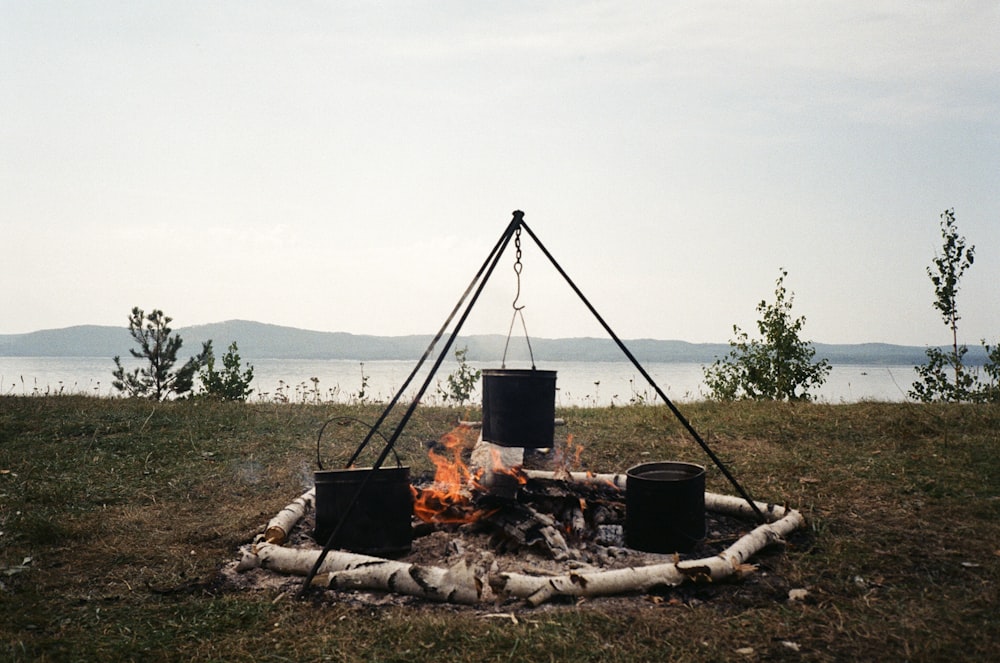 a campfire with buckets sitting on top of it