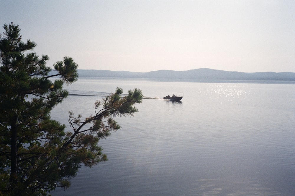 山々を背景にした穏やかな湖の上の孤独なボート