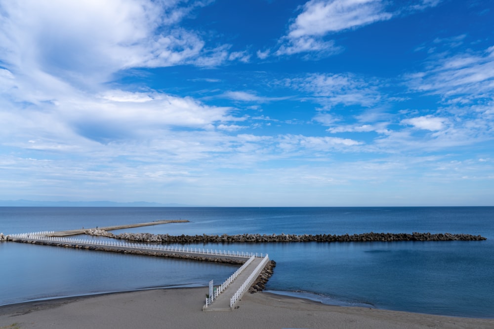 a pier on a beach next to a body of water