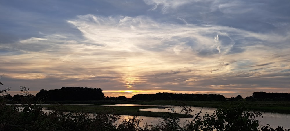 the sun is setting over a body of water