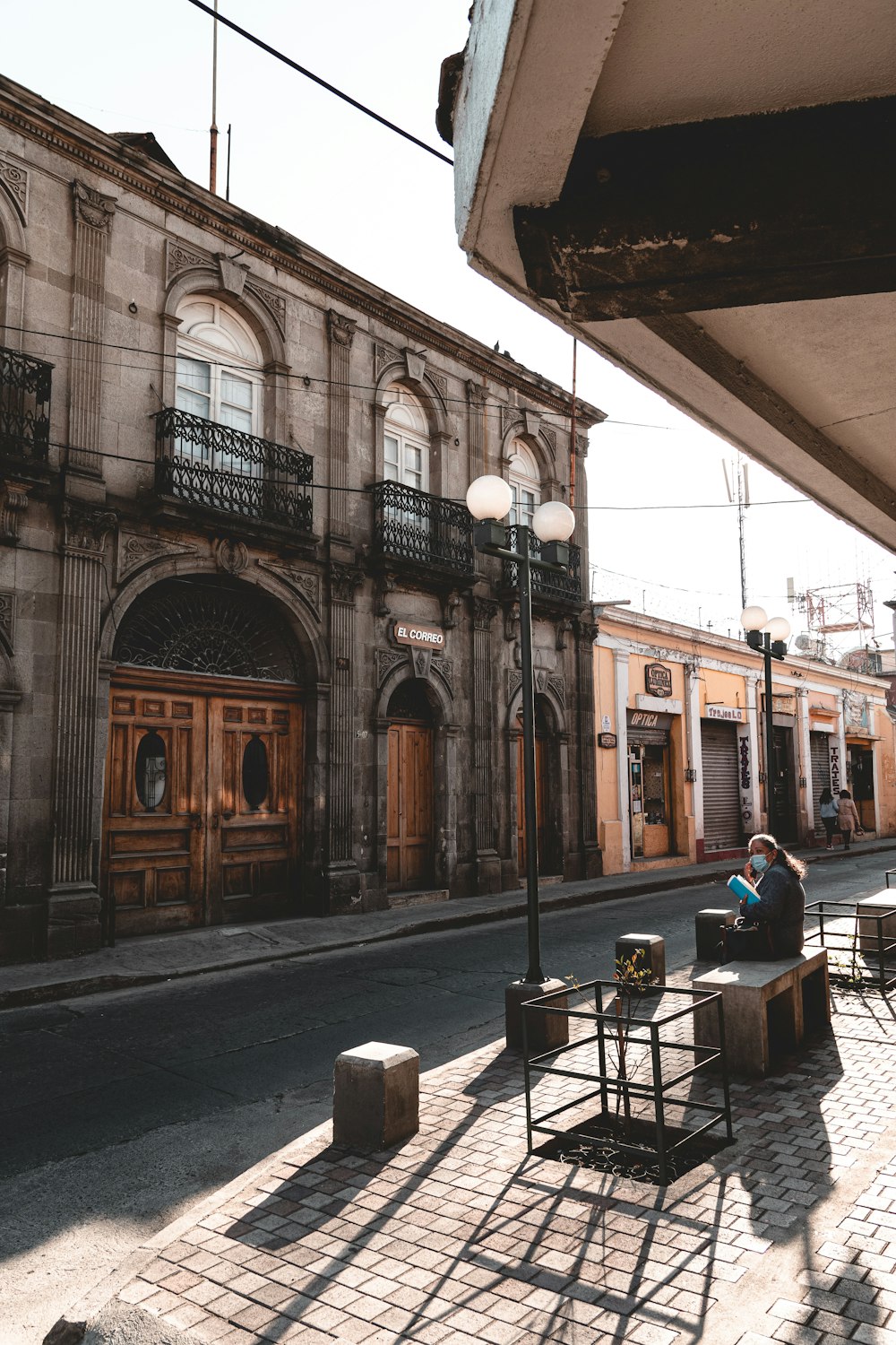 a person sitting on a bench in front of a building