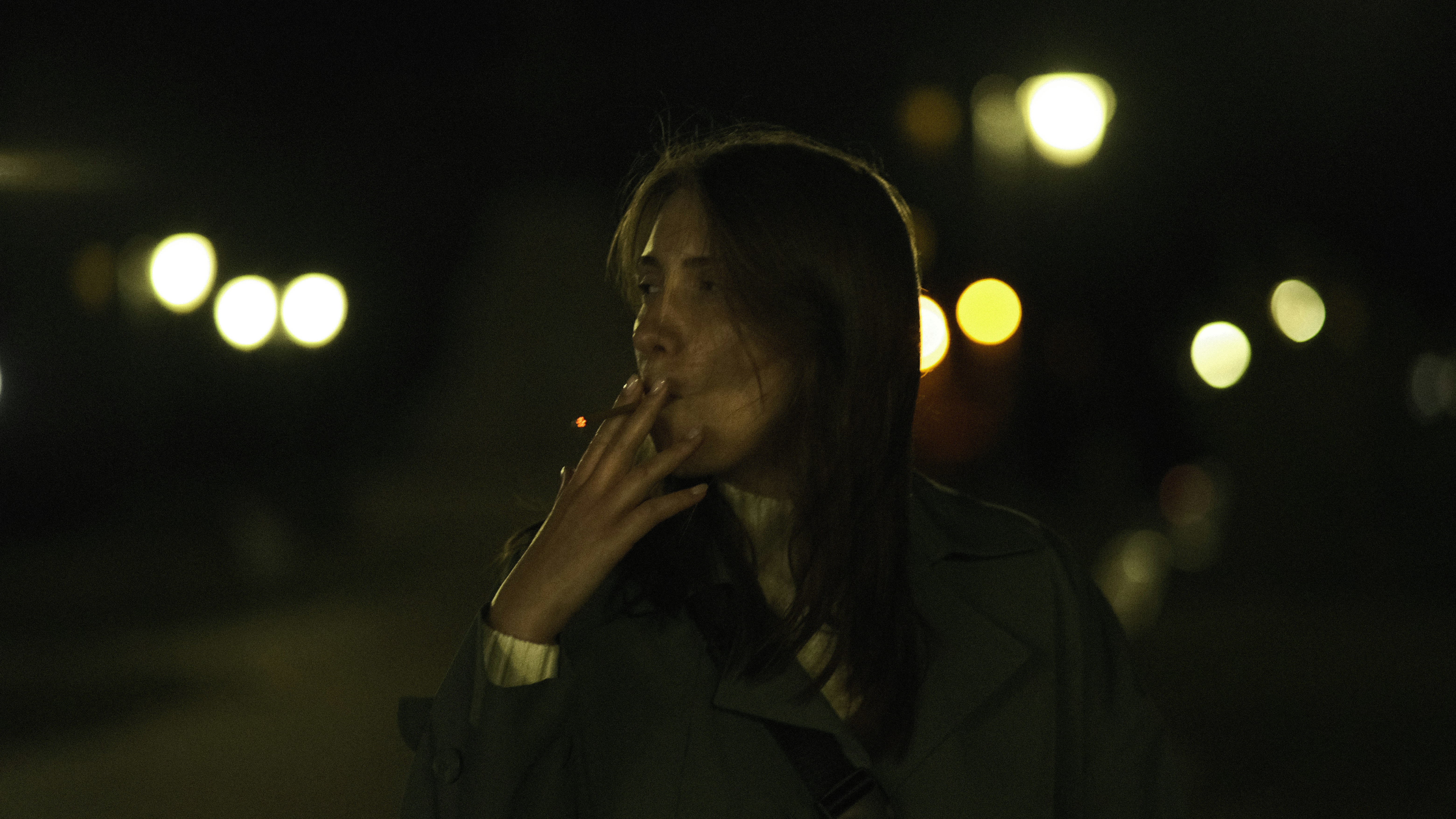 a woman smoking a cigarette in the dark