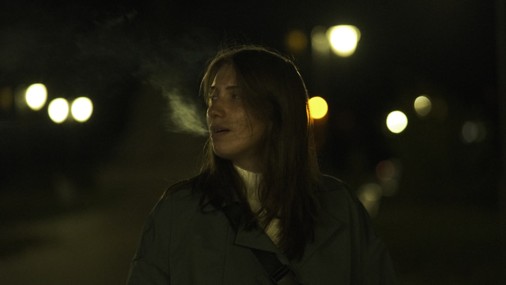 a woman smoking a cigarette in the dark