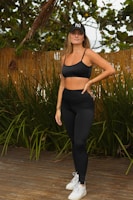 a woman in a black sports bra top and leggings