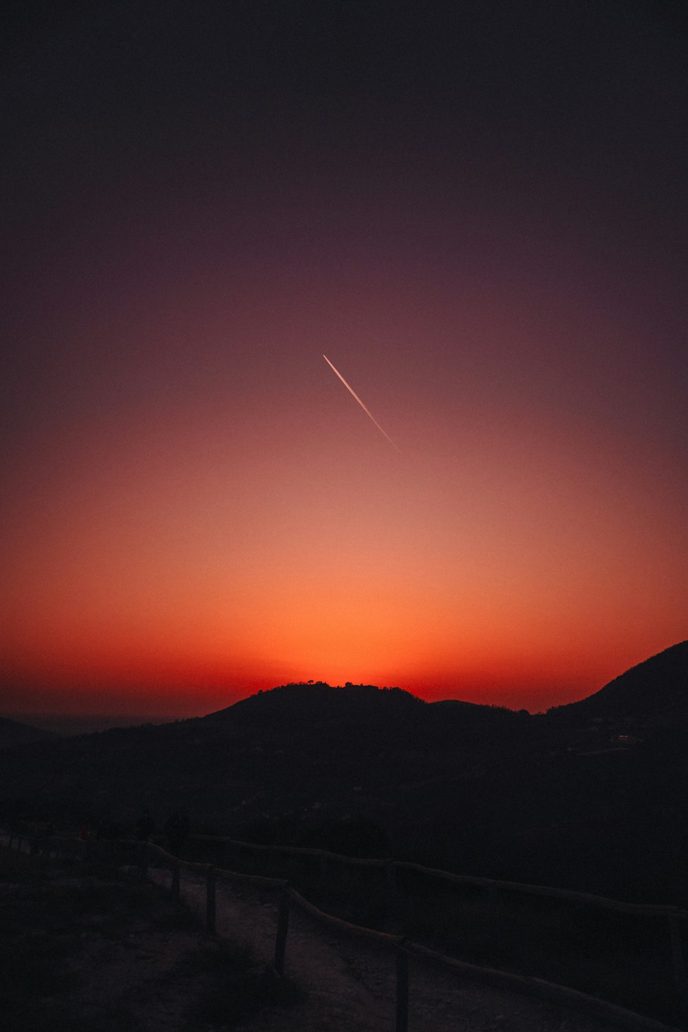 Un tramonto con un aereo che vola nel cielo