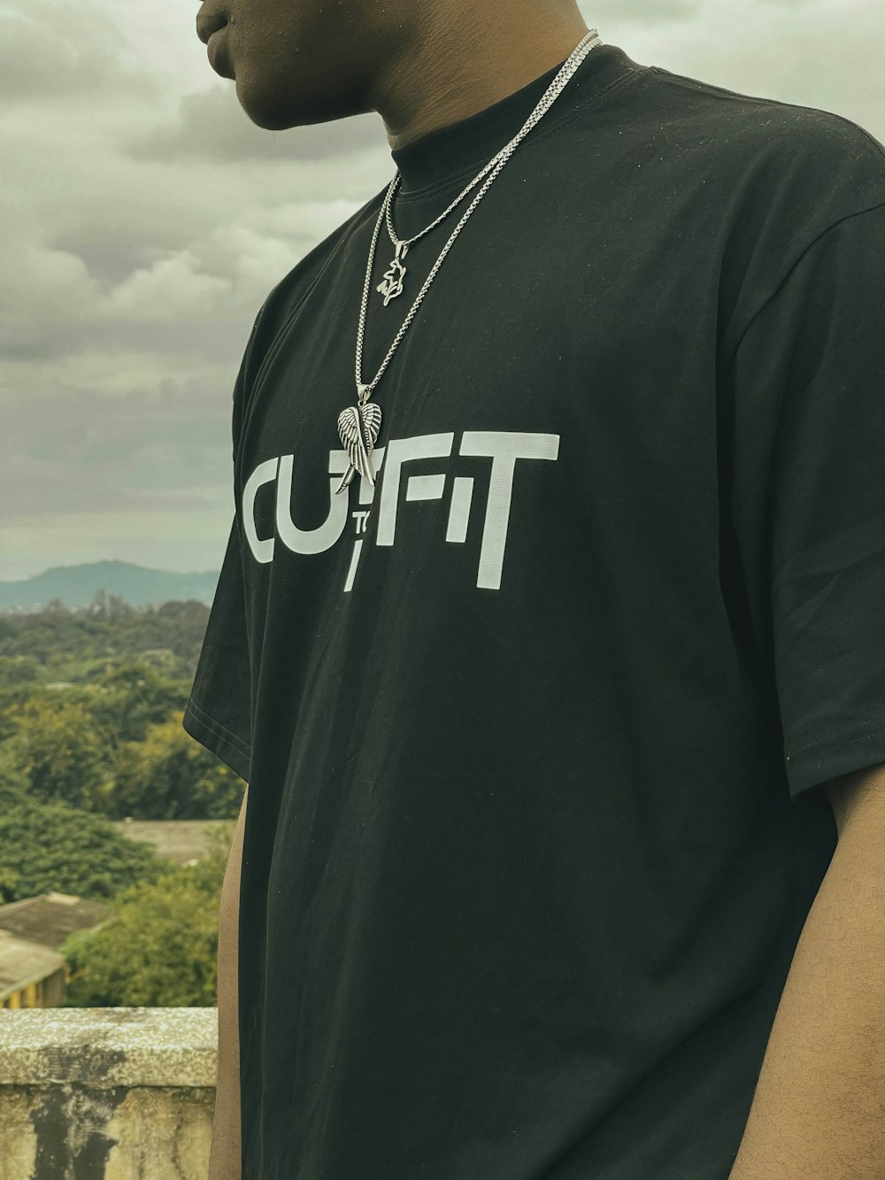 a man wearing a black shirt and a necklace