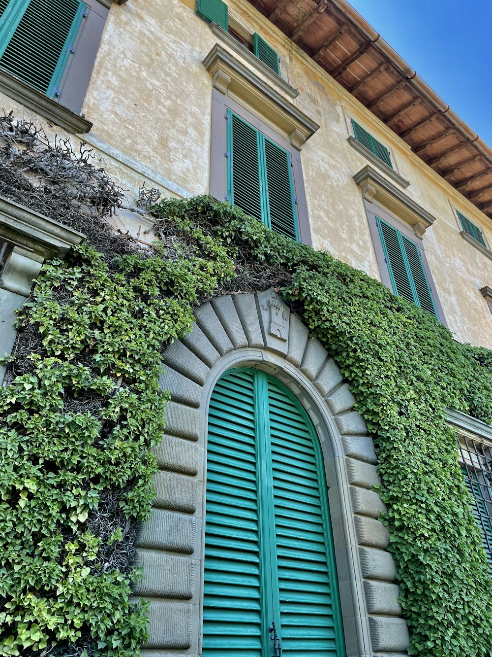 a building with green shutters and a green door