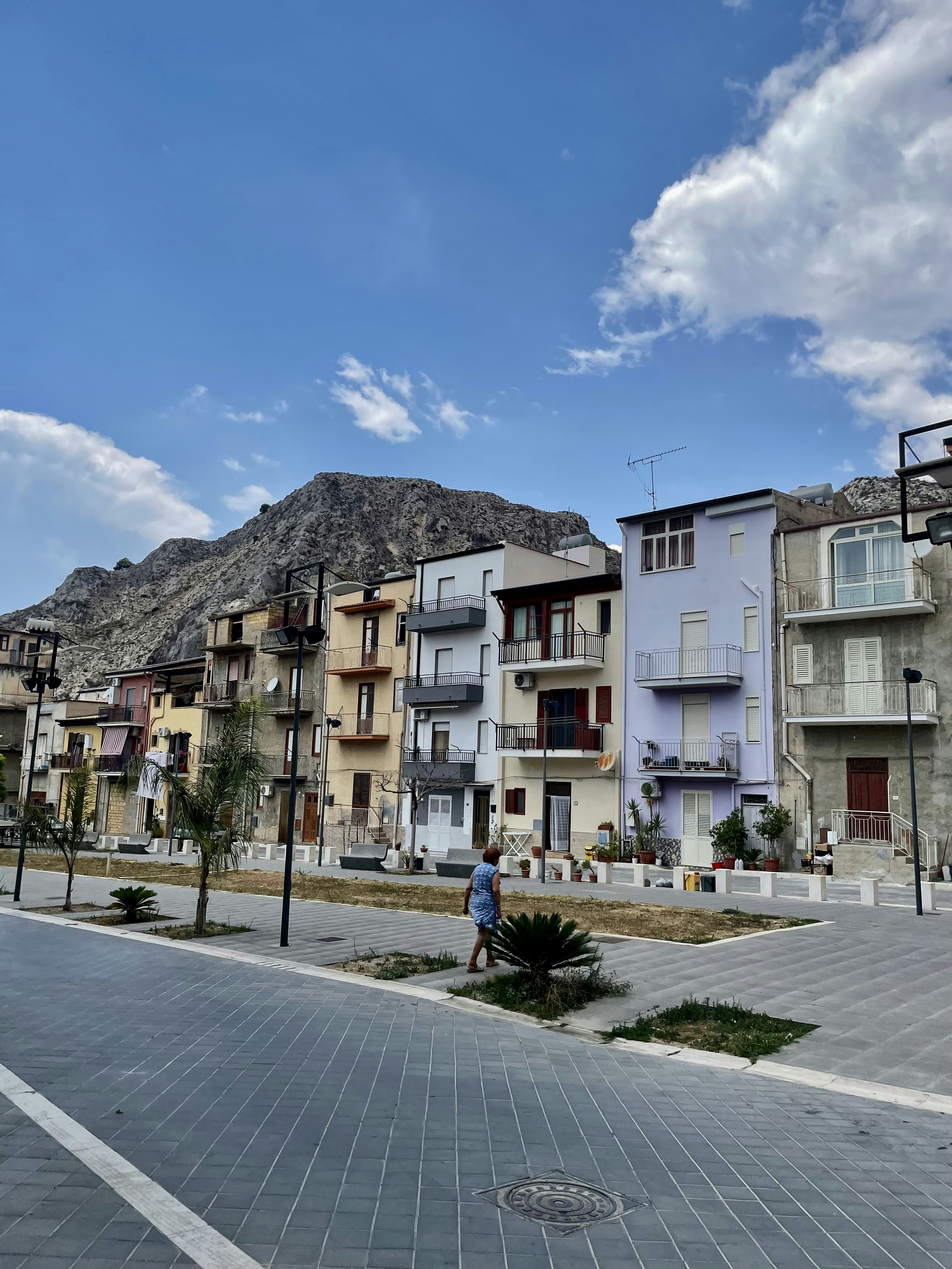 a man walking down a street next to tall buildings