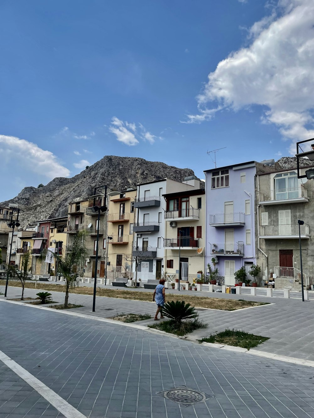 Un homme marchant dans une rue à côté de grands immeubles