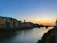 Sunset over the serene Garonne river with quaint village houses along the shore.