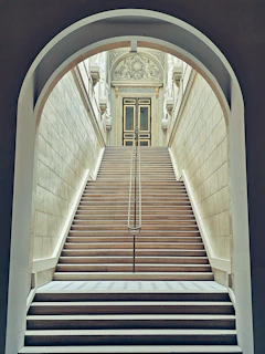 Wide granite staircase leading up to a grand entrance with intricate stone detailing