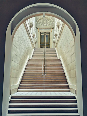Wide granite staircase leading up to a grand entrance with intricate stone detailing