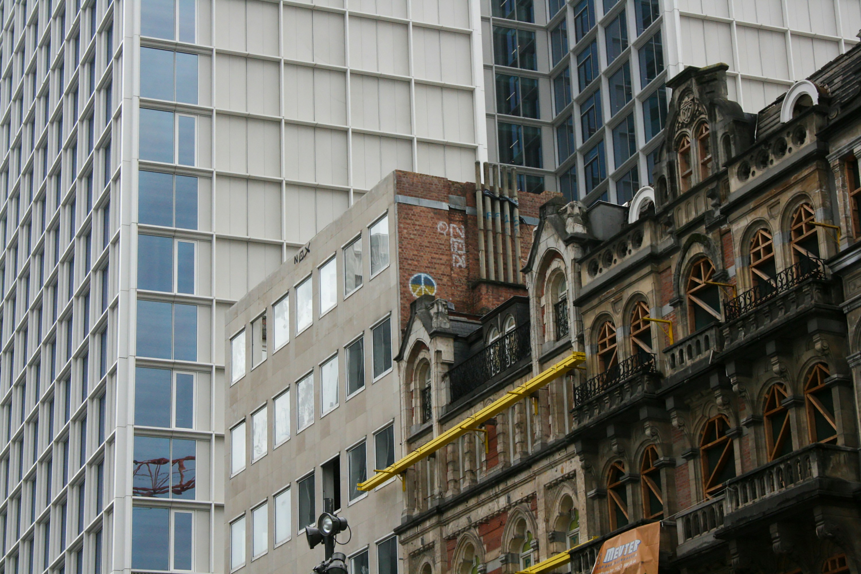 a tall building with lots of windows next to other buildings