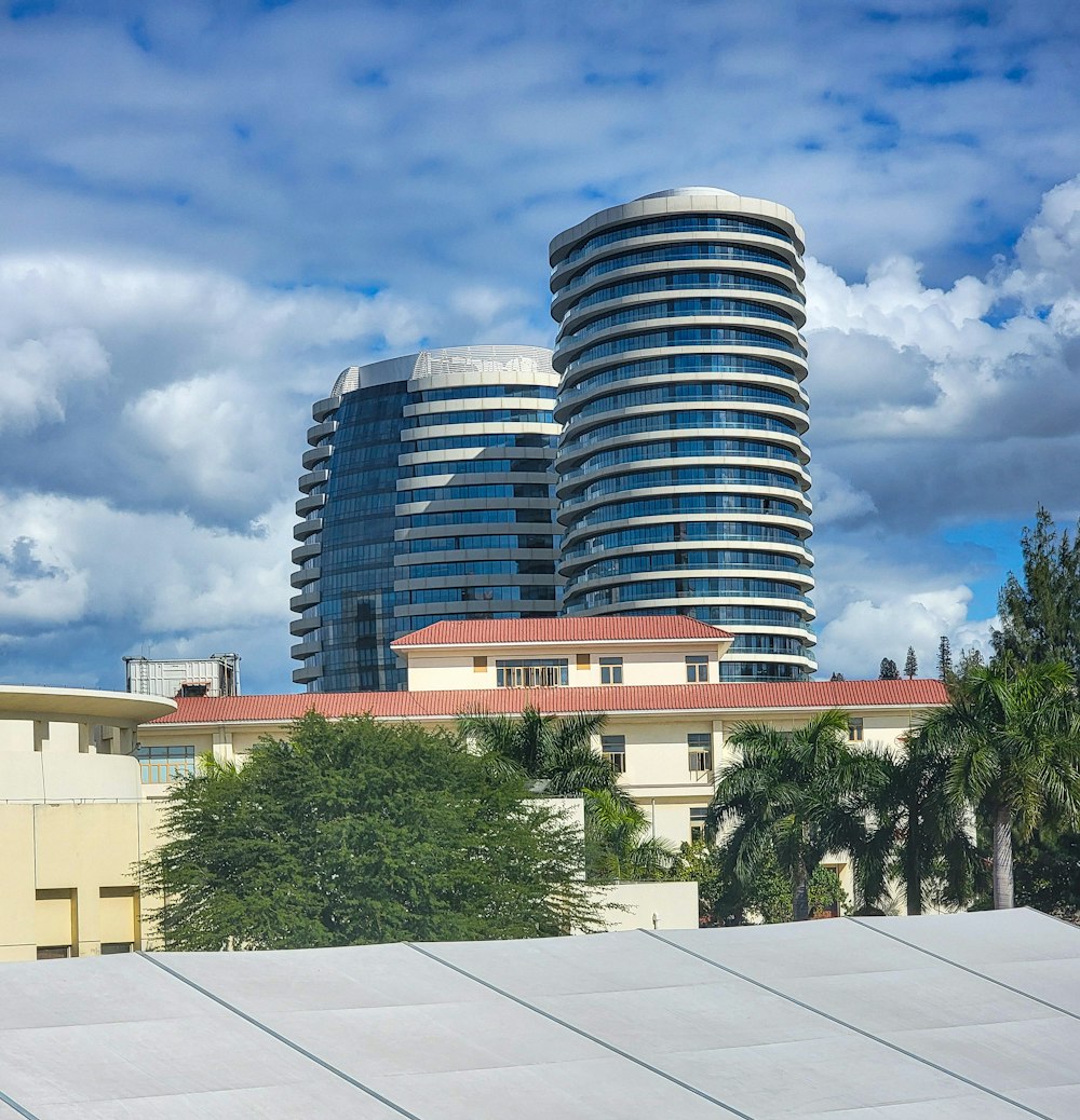 a tall building with a red roof next to palm trees