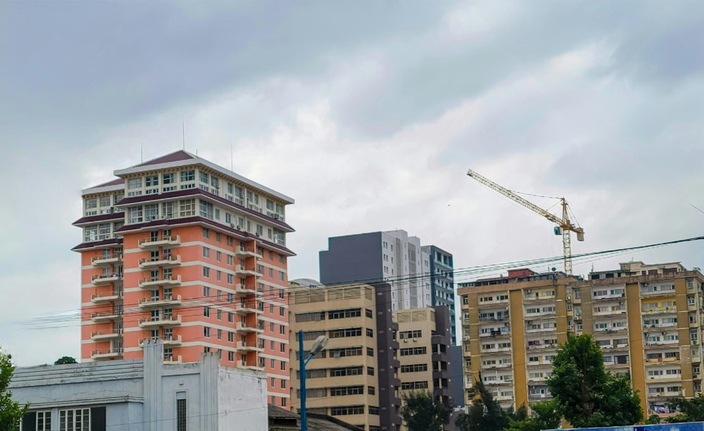 a group of buildings with a crane in the background