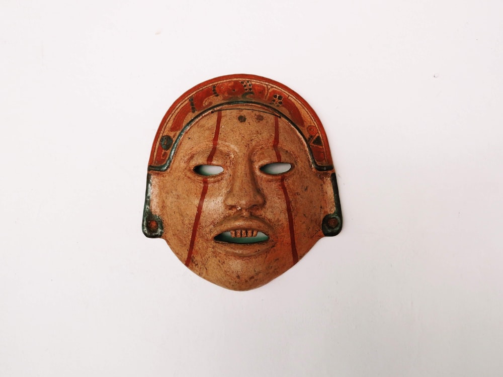 a wooden mask hanging on a wall