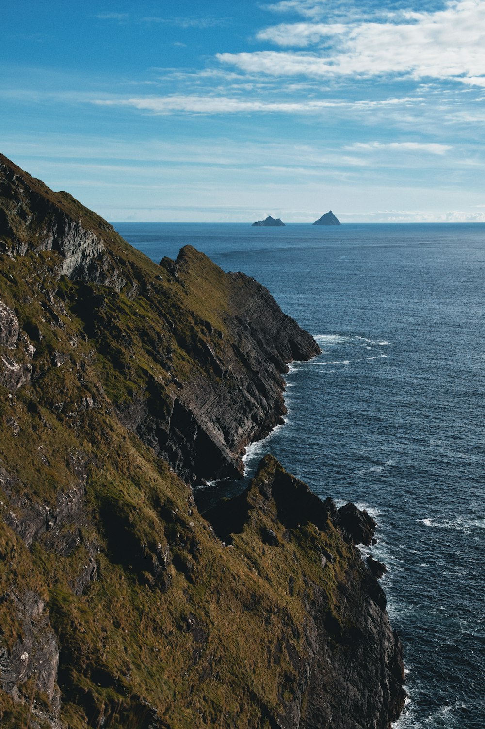 a rocky cliff with a body of water in the background