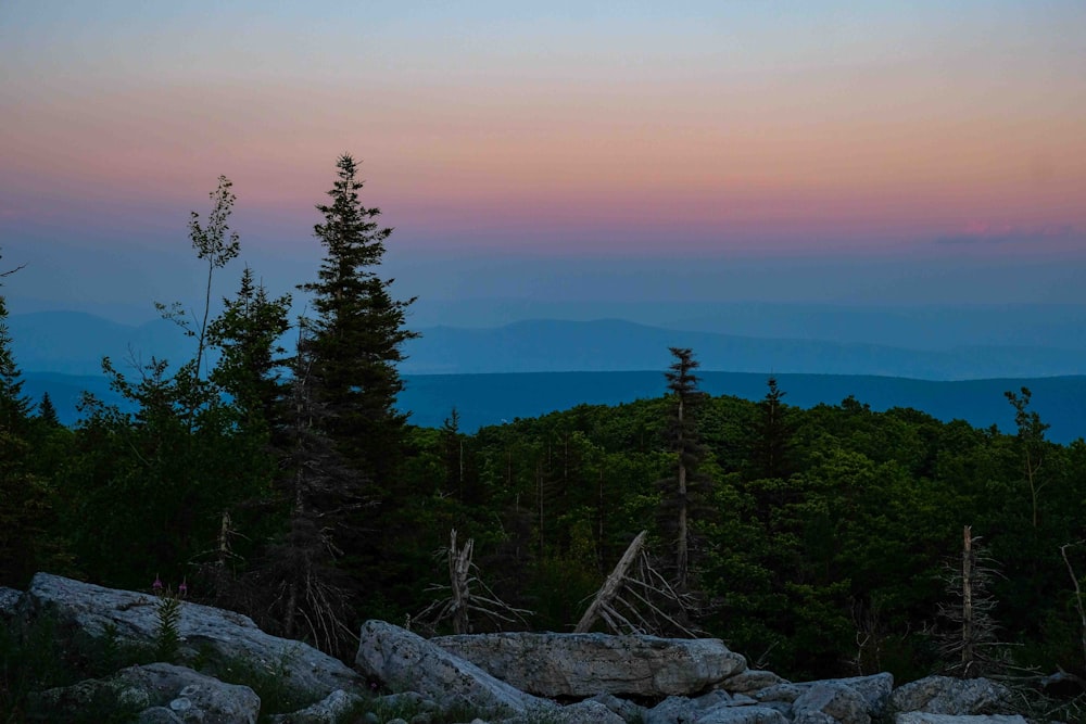 the sun is setting over the mountains in the distance