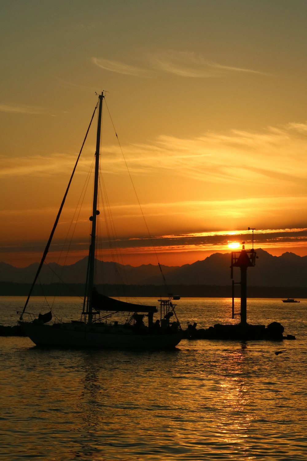 a sailboat in the water at sunset