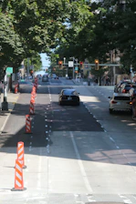 Aerial view of a city street with clearly marked detour routes and traffic cones.