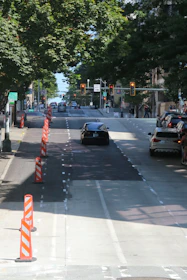 Aerial view of a city street with clearly marked detour routes and traffic cones.
