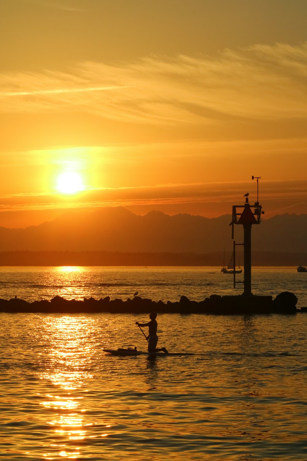 a person in a kayak on a body of water at sunset