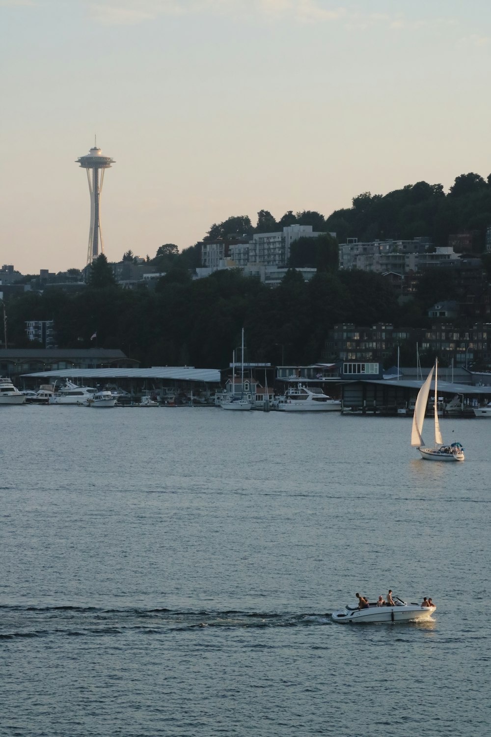 a sailboat in the water with a city in the background